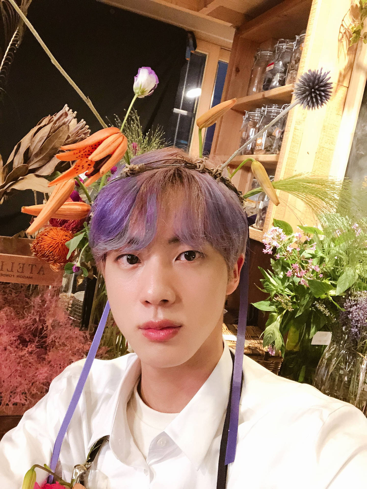 紫髮年輕男子戴著花冠在花店