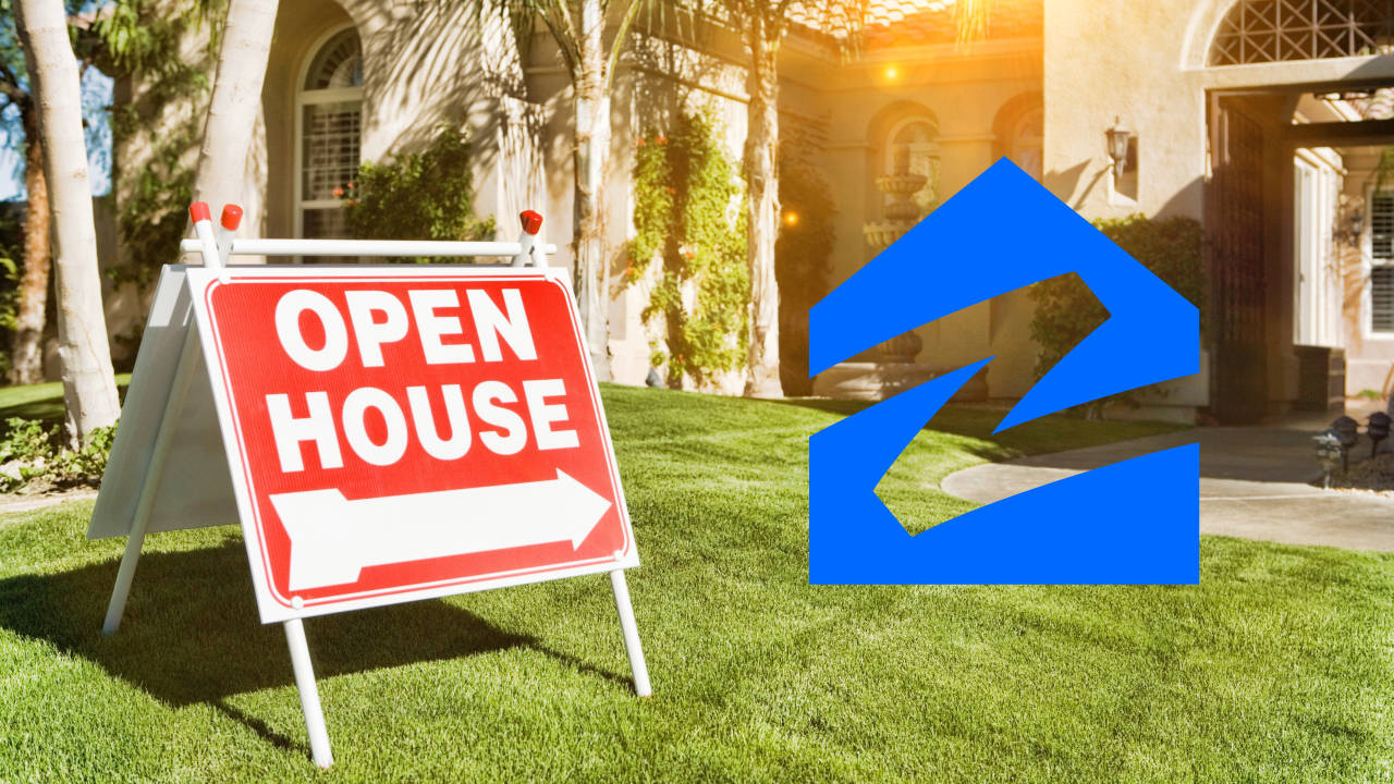 Zillow 網站上的歡迎開放參觀房屋 壁紙 — 一個紅色開放日標誌，白色箭頭指向右方，位於茂盛綠色草坪上，前方是陽光照射的灰泥房屋和棕櫚樹。