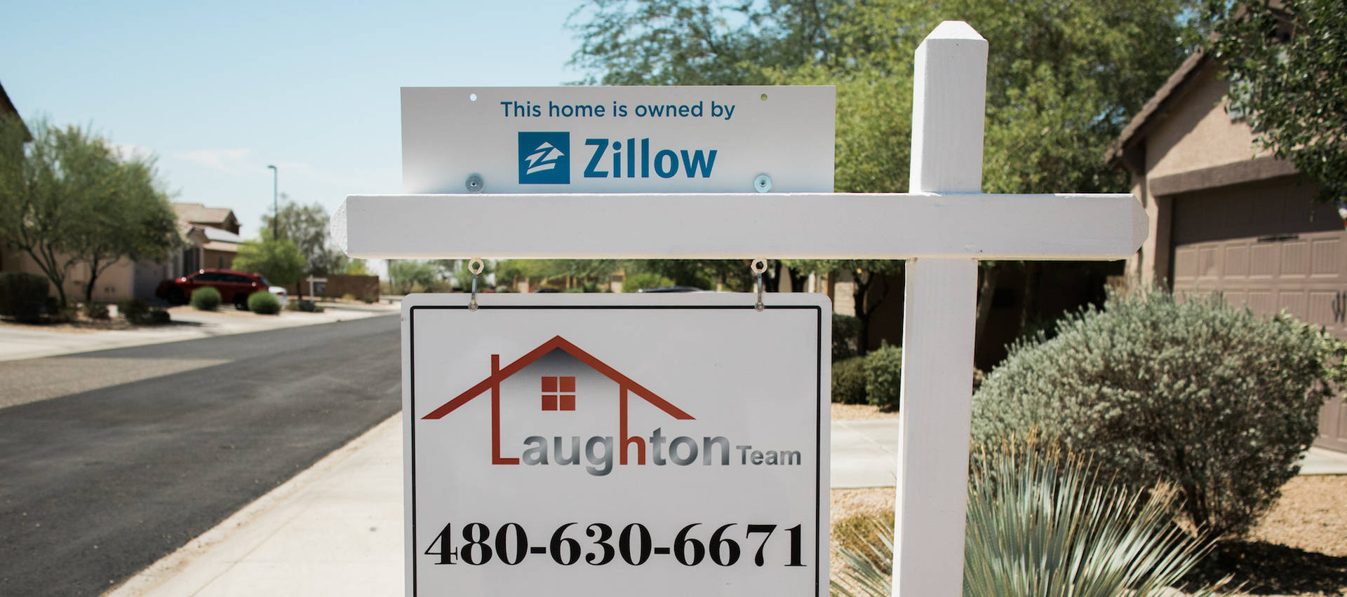 沙漠郊區社區中 Zillow 和 Laughton Team 的房地產標誌。