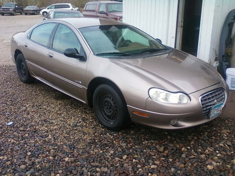 Chrysler Lhs 桌布 壁紙 — 一輛棕褐色Jaguar S-Type轎車配黑色輪圈，停在白色車庫門前的礫石上。