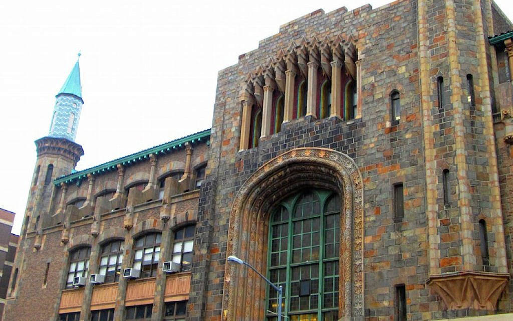 葉希瓦大學Zysman Hall綠色尖塔 壁紙 — 宏偉石建築，飾有拱形窗戶和藍綠色尖頂，天空多雲。