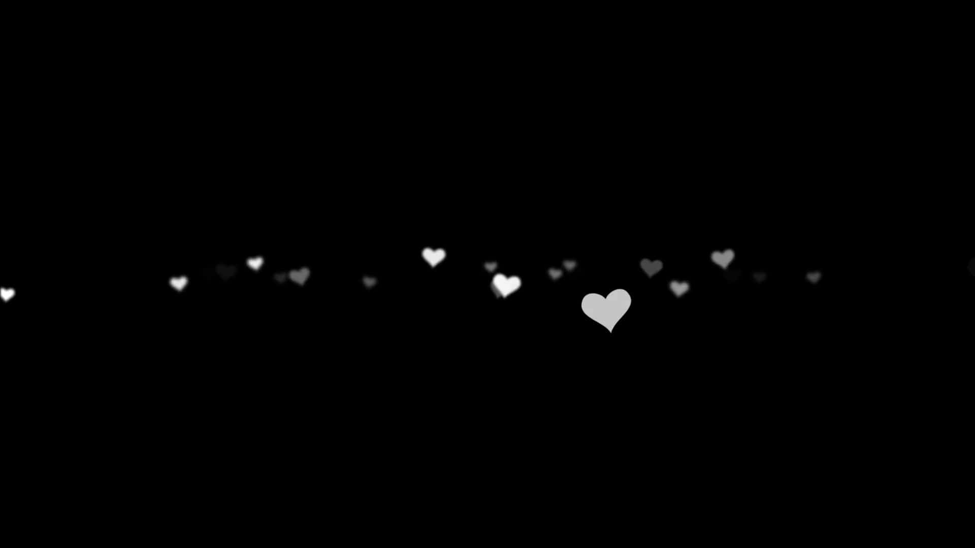 Black And White Heart 桌布 壁紙 — 一串發光的白色心形在柔焦中飄過深邃的黑色虛空。