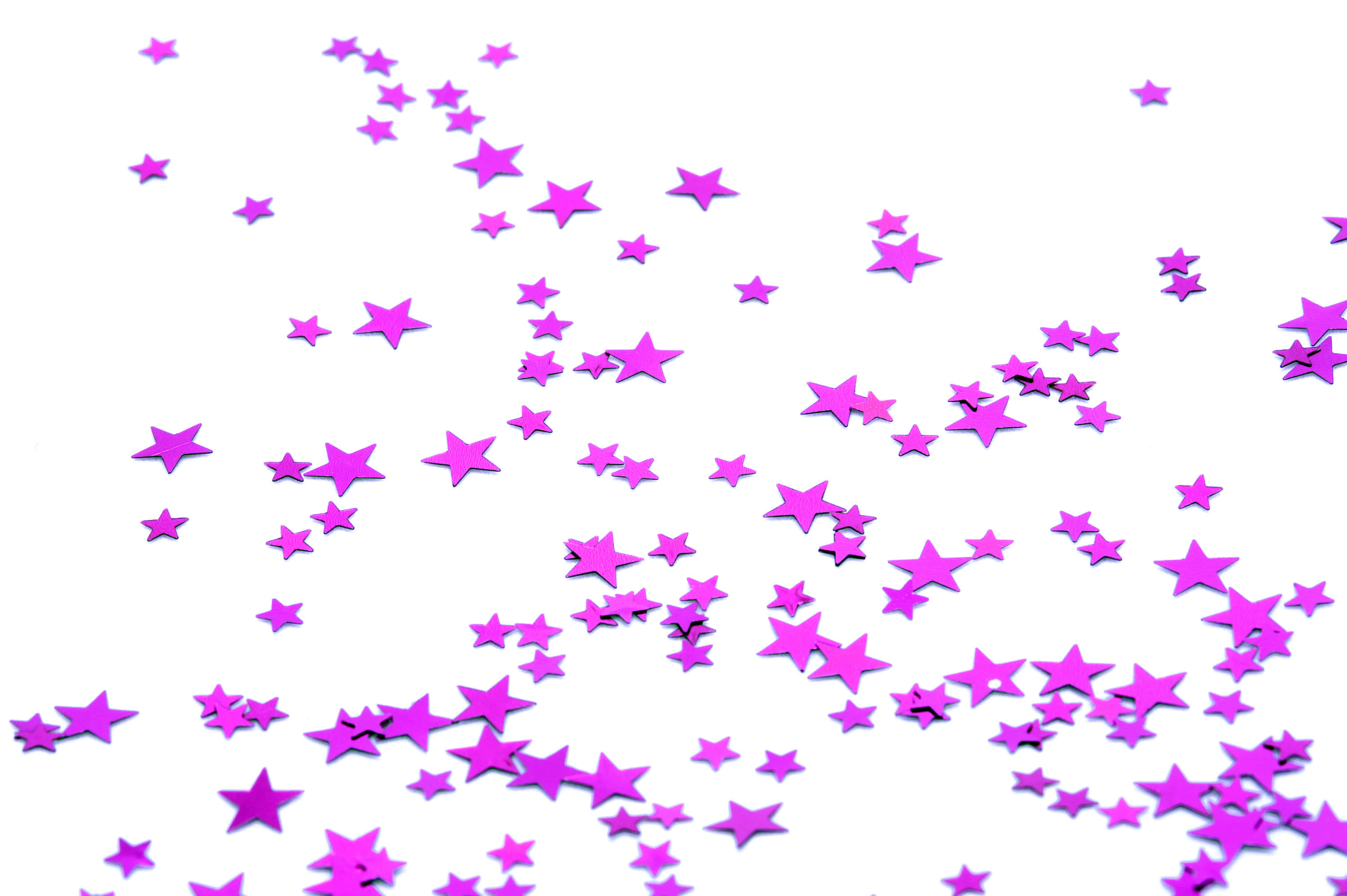 Pink Stars 桌布 壁紙 — 一串鮮豔的紫色星形紙屑散落在潔淨的白色背景上。