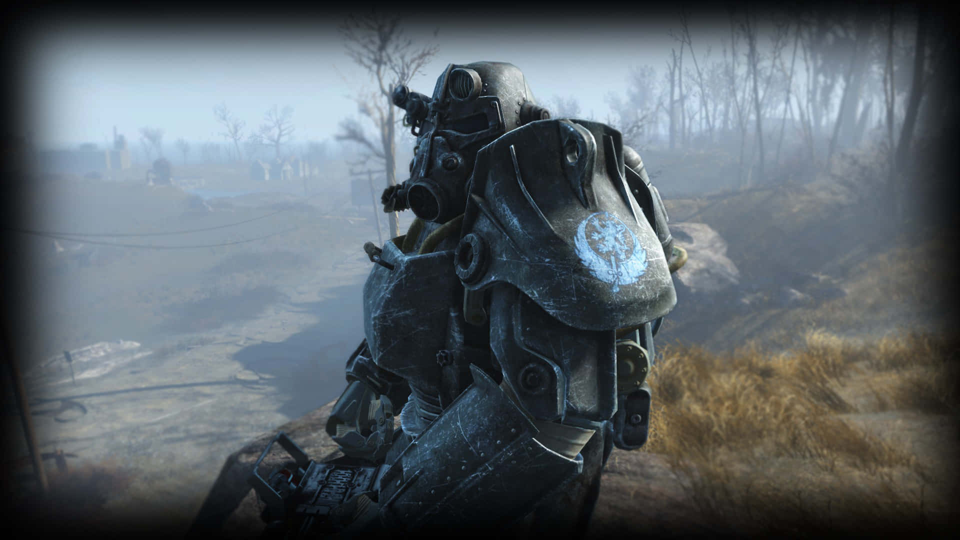 Fallout 4 Power Armor 桌布 壁紙 — 一件風化的動力裝甲套裝矗立在荒涼、霧氣瀰漫的廢土上，背景是貧瘠的樹木和破敗的建築。