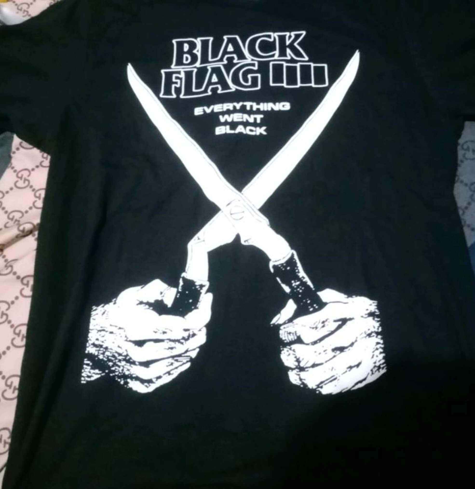 Black Flag Band 桌布 壁紙 — 一件黑色T恤，上面有白色圖案，顯示兩隻手緊握交叉的刀，並印有「BLACK FLAG III EVERYTHING WENT BLACK」文字。