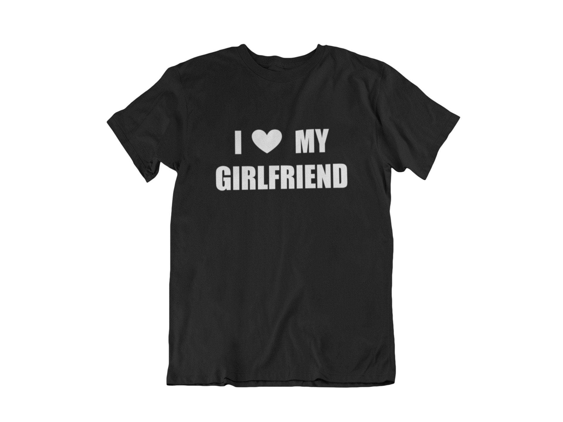Girlfriend 桌布 壁紙 — 一件黑色T恤，上面有白色文字寫著「我 ❤️ 我的女朋友」，平放在白色背景上。