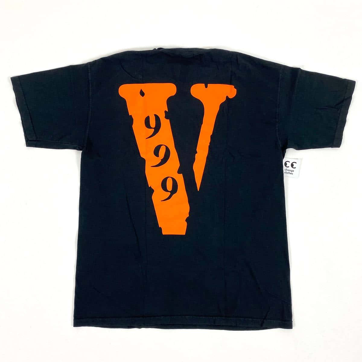 Vlone 桌布 壁紙 — 一件黑色復古T恤，背面有醒目的橙色「V999」圖案，平放在白色背景上。