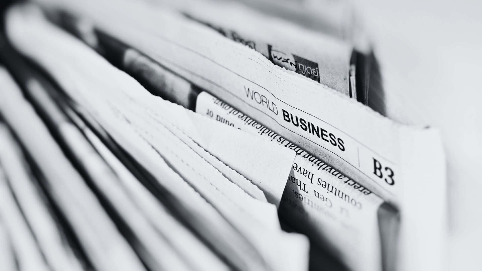 Black And White Newspaper 桌布 壁紙 — 一份黑白特寫，聚焦於疊起的報紙版面，清晰可見「WORLD BUSINESS」和「B3」。