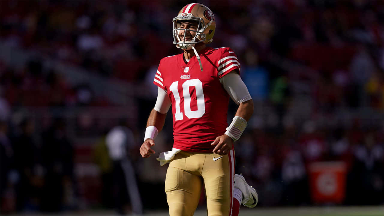 Jimmy Garoppolo 桌布 壁紙 — 一位三藩市四九人隊的四分衛身穿紅金色球衣，在陽光明媚的比賽中自信地微笑。