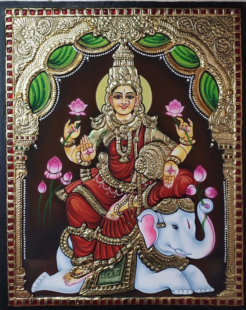  壁紙 — 一位光彩照人的印度教女神，身穿紅金色服飾，優雅地坐在一頭飾有珠寶的白象上，手持粉紅蓮花，背景深色，飾有華麗的金色拱門框架。