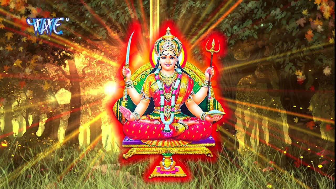 Goddess 桌布 壁紙 — 一位光芒四射的印度教女神，有四隻手臂，盤腿坐在森林中的寶座上，手持劍和三叉戟，被金色光線包圍。