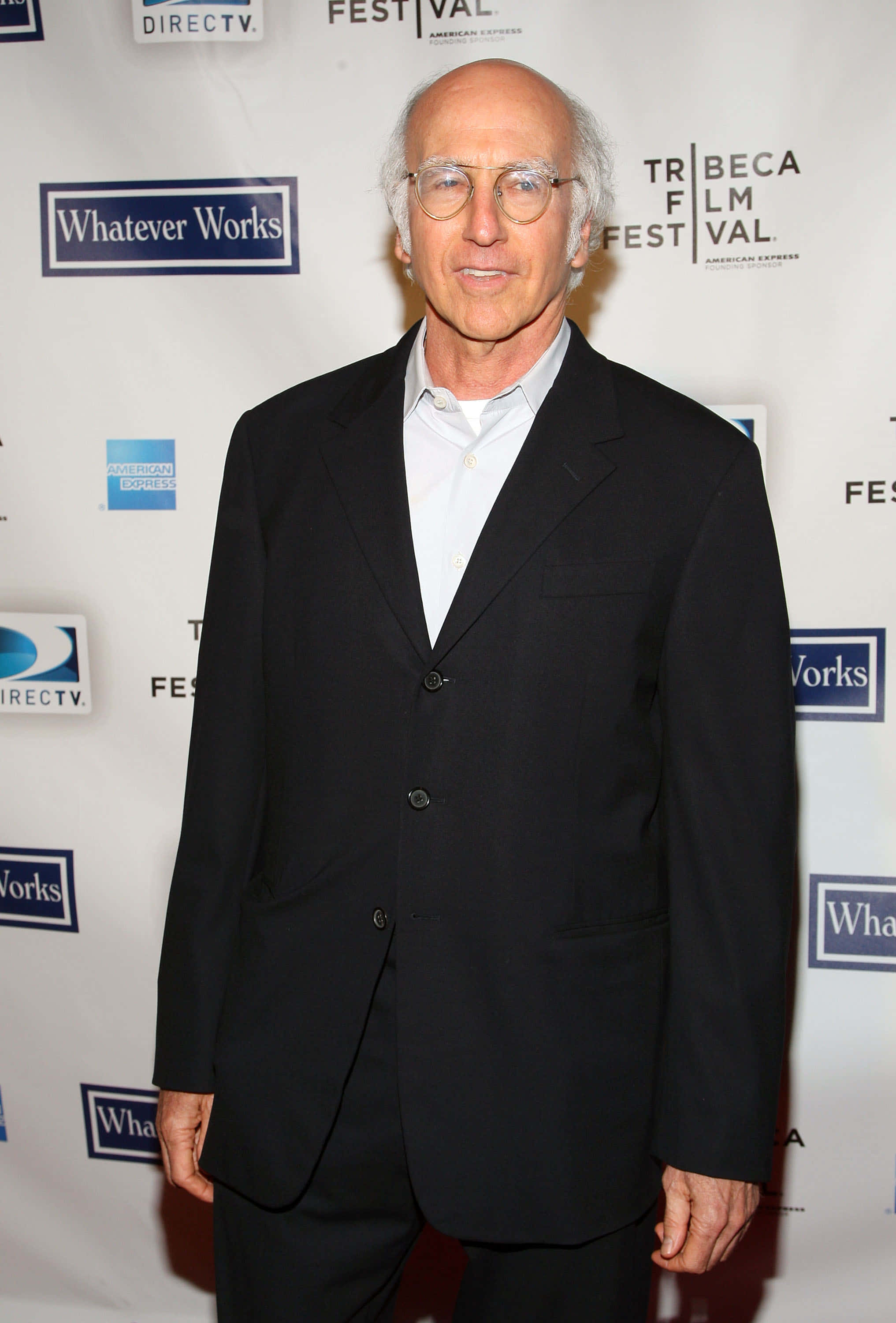 larry david 桌布 壁紙 — 一位光頭戴眼鏡的男子在Tribeca電影節活動中穿著黑色西裝和白色襯衫。