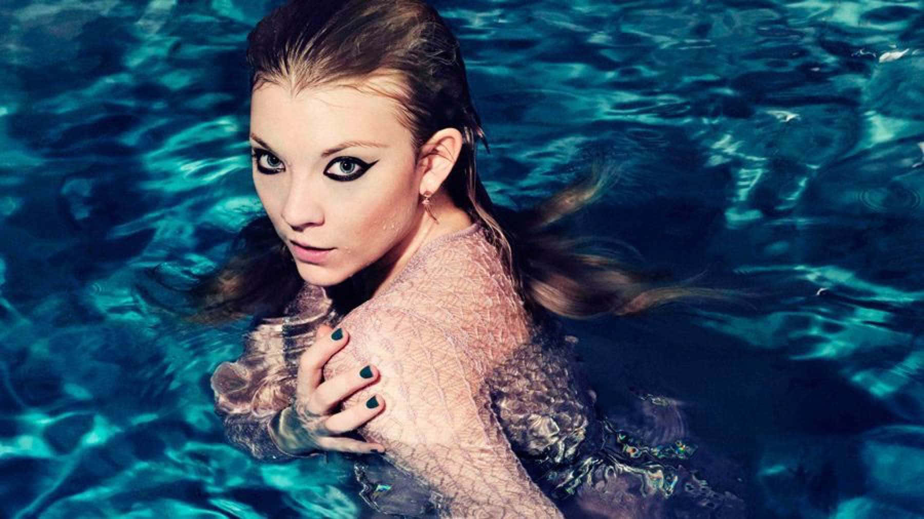 natalie dormer 桌布 壁紙 — 一位化著濃妝、頭髮濕透的女性從藍綠色的泳池水中浮現，直視鏡頭。