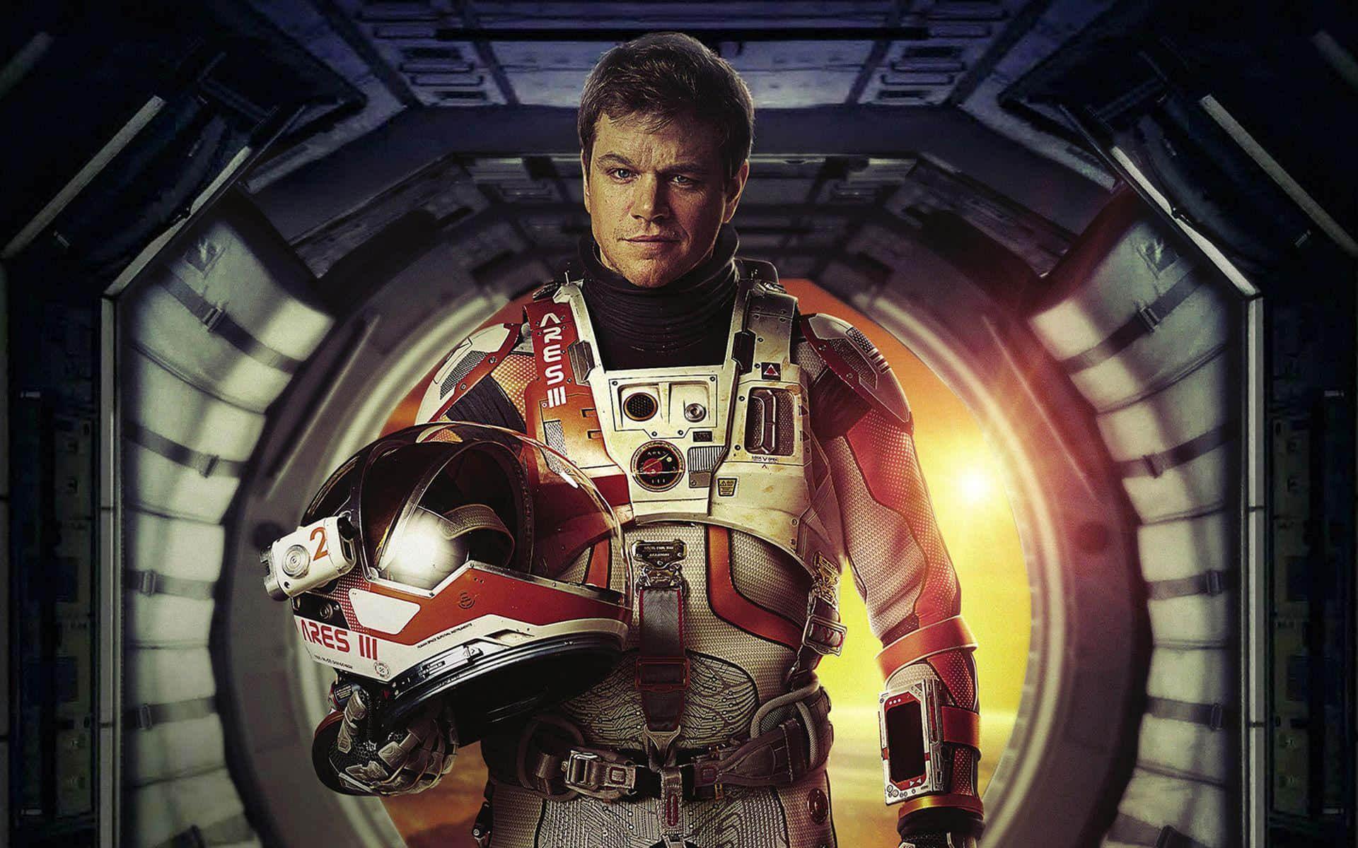 The Martian 桌布 壁紙 — 一位堅定的太空人穿著紅白太空衣，站在太空船走廊上，手持頭盔，身後有明亮的太陽發光。