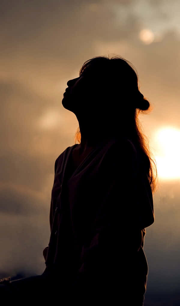 一位女士在夕陽下呈現剪影 壁紙