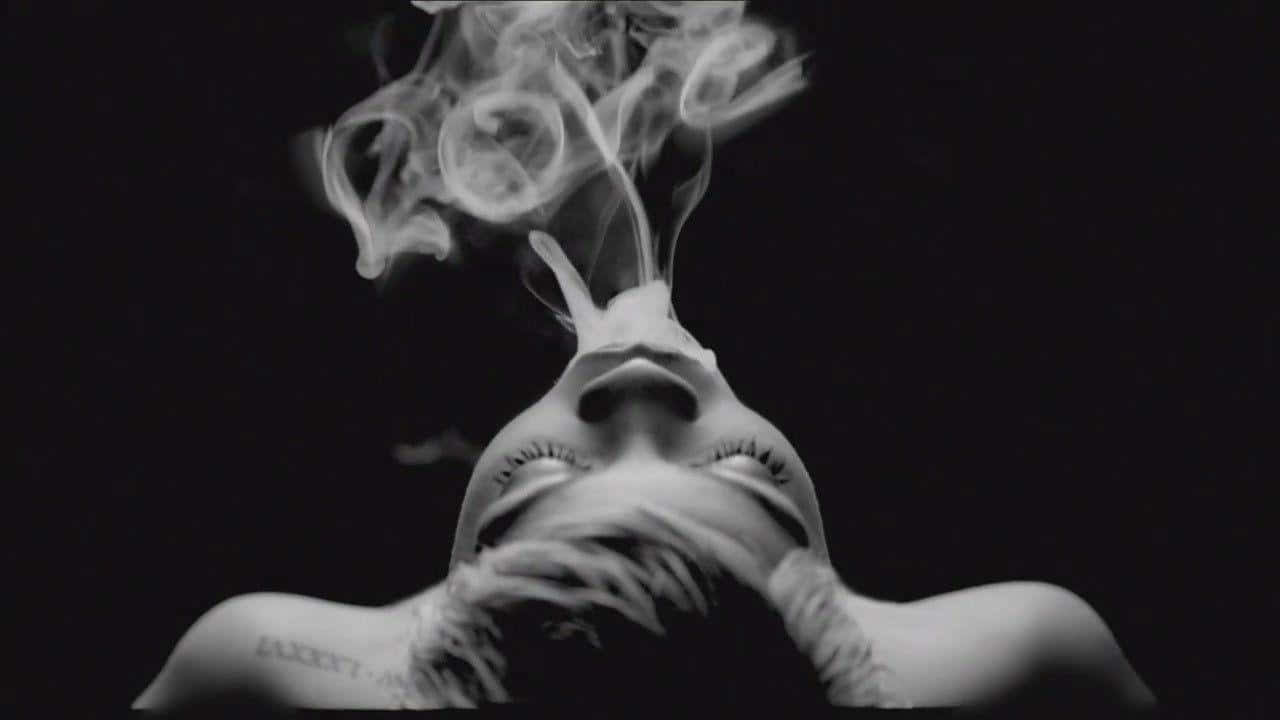 一位女士在黑色背景前抽煙 壁紙