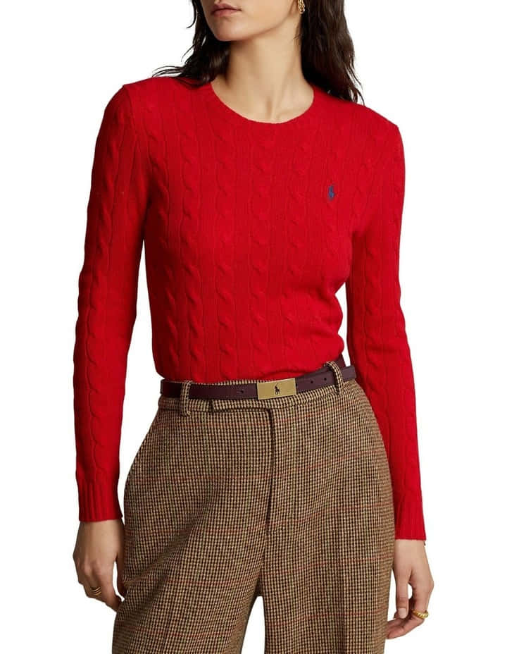 Red Sweater 桌布 壁紙 — 一位女士穿著一件鮮紅色嘅纜繩針織毛衣，上面有個細細嘅藍色標誌，同埋一條啡色嘅千鳥格褲，用一條金色扣嘅啡色皮帶束住。