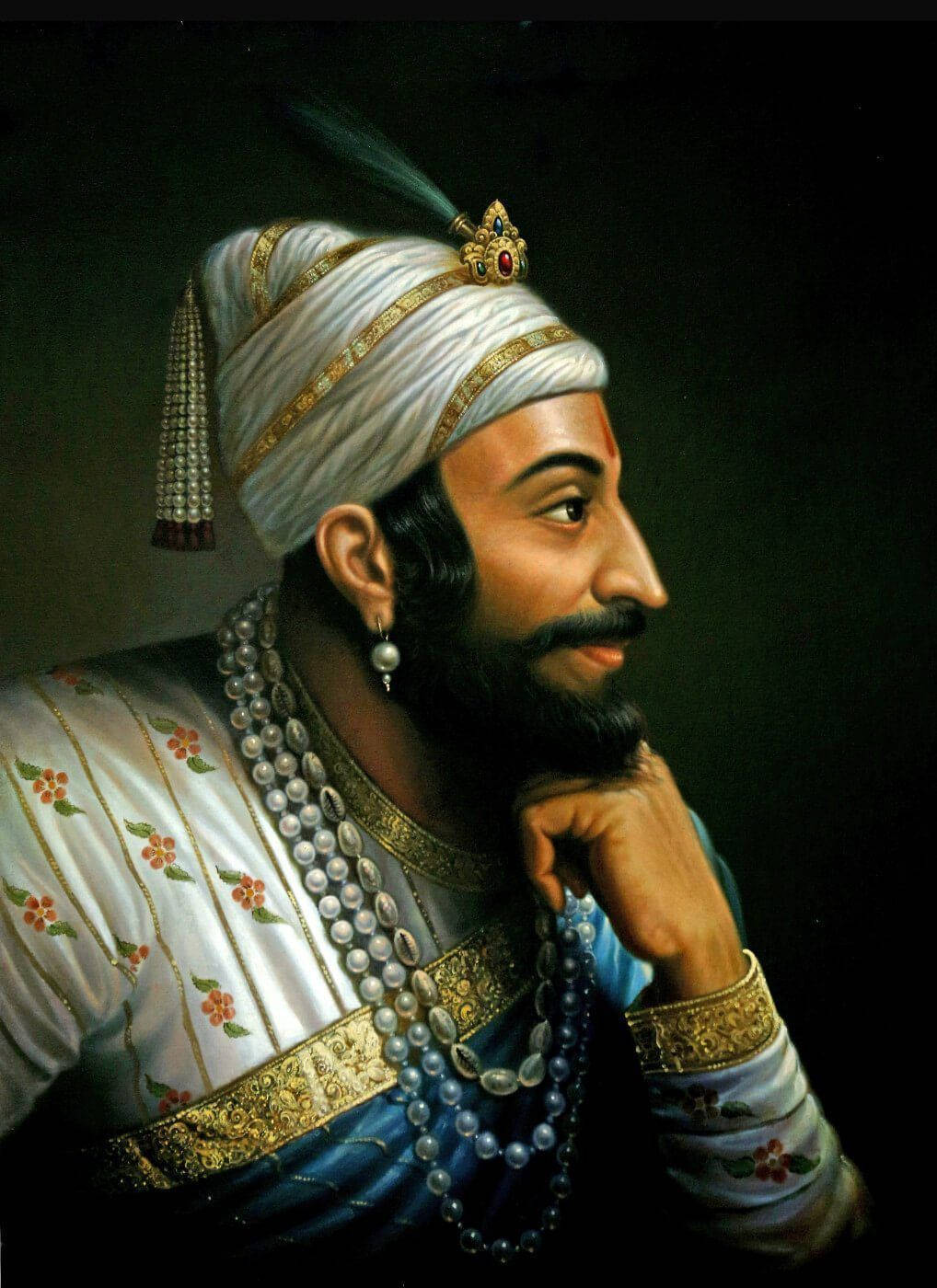 Chhatrapati Shivaji Maharaj 桌布 壁紙 — 一位威嚴的男子身穿飾有珍珠和花卉刺繡的華麗白色與金色長袍，在黑暗背景下若有所思地凝視著。
