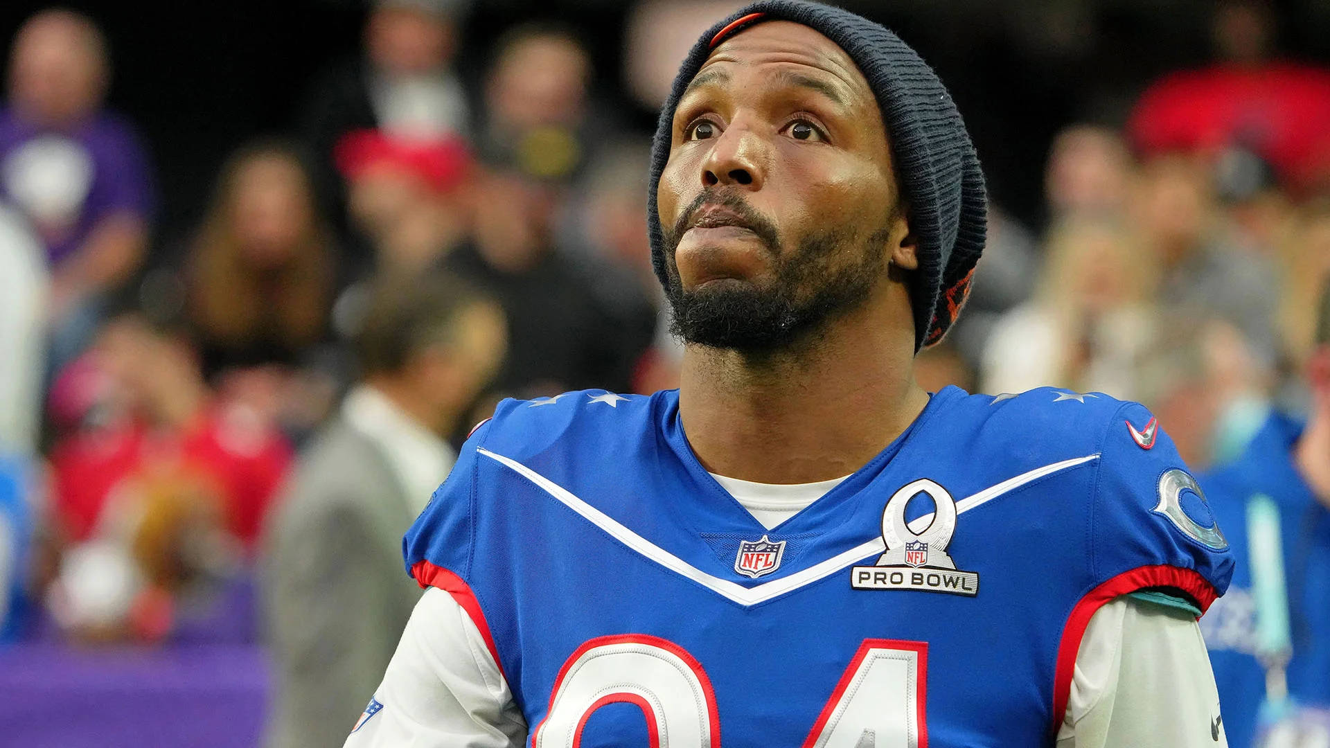 Robert Quinn NFL Pro Bowl 壁紙 — 一位專注的NFL球員身穿藍色Pro Bowl球衣，在球場燈光下比賽時向上凝視，神情專注。