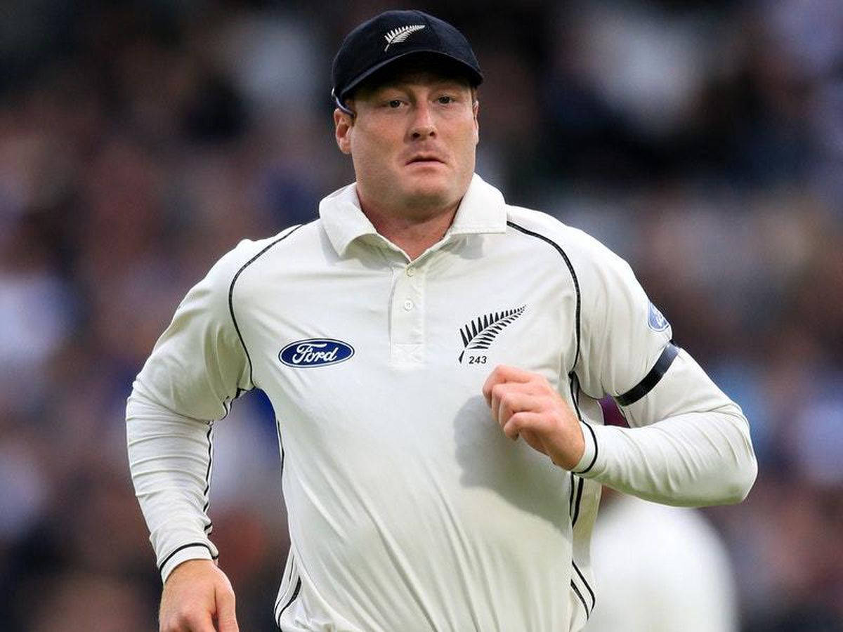 martin guptill 桌布 壁紙 — 一位專注的新西蘭板球運動員身穿白色制服在場地上奔跑，背景是模糊的觀眾。