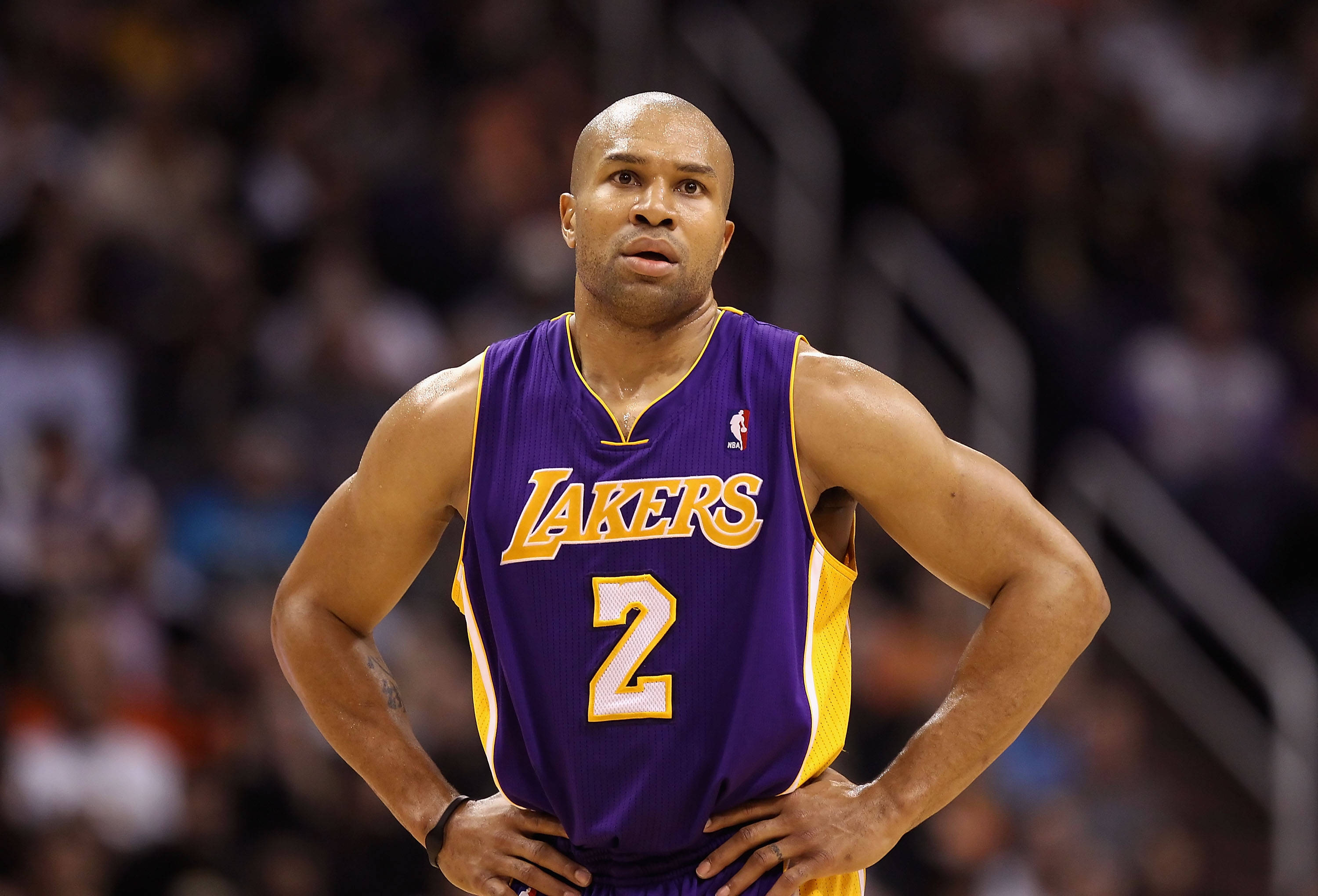 NBA 桌布 壁紙 — 一位專注的籃球運動員身穿紫金色湖人球衣，在比賽中雙手叉腰站立。