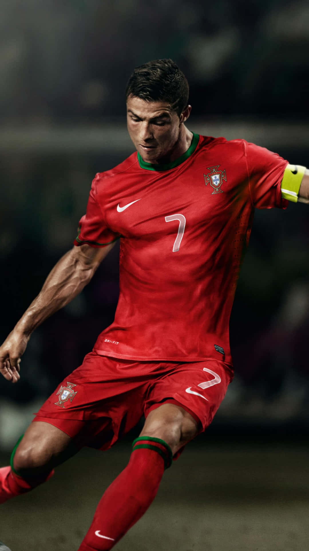 Ronaldo 桌布 壁紙 — 一位專注的足球員身穿紅色葡萄牙球衣7號，在球場燈光下激烈盤球。