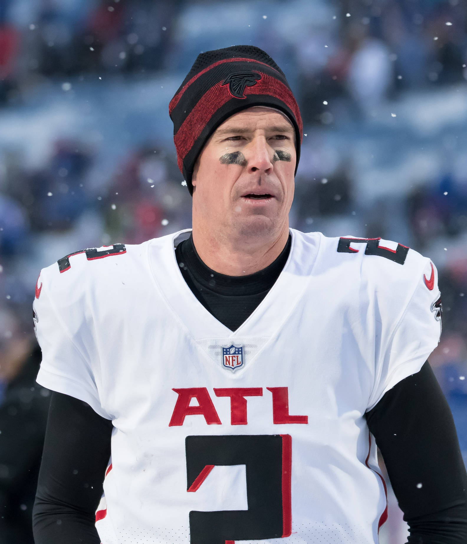 Matt Ryan 桌布 壁紙 — 一位專注的阿特蘭大獵鷹四分衛在冬季NFL比賽中戴著冷帽和眼部黑色塗料站在雪中。