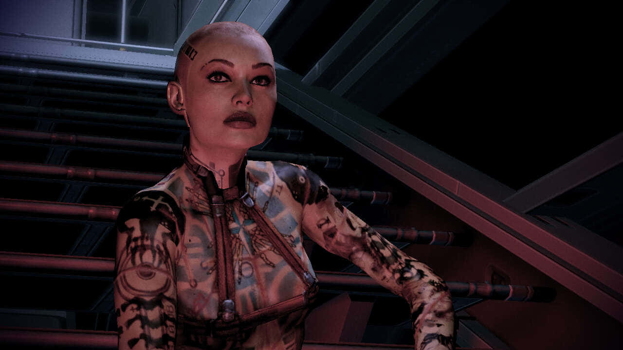 Mass Effect Jack 桌布 壁紙 — 一位帶有紋身和機械手臂的賽博格女性，站在一個有管道和金屬橫樑的昏暗工業環境中。