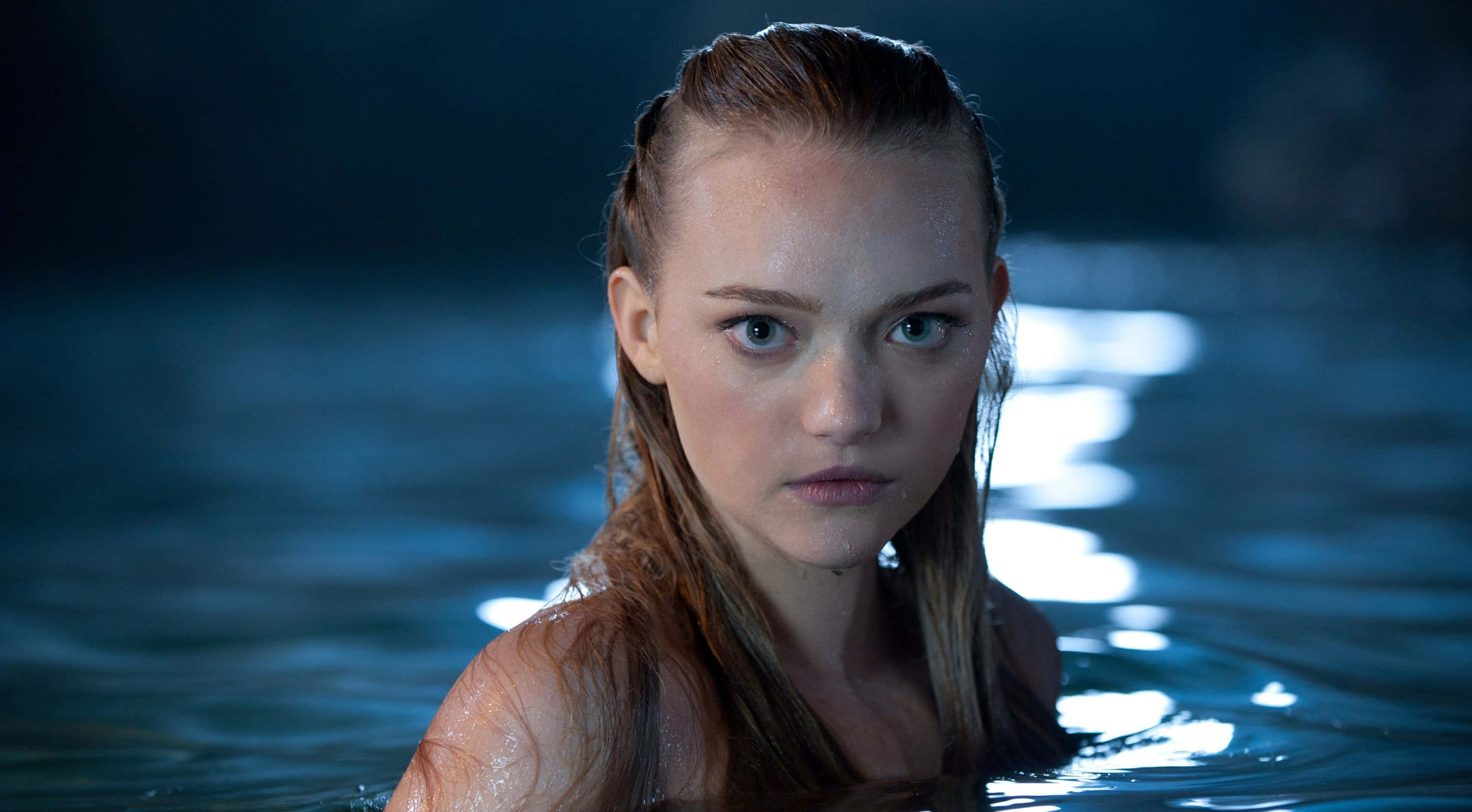 Gemma Ward 桌布 壁紙 — 一位年輕女子濕髮在昏暗燈光下從深藍色水中凝視著。