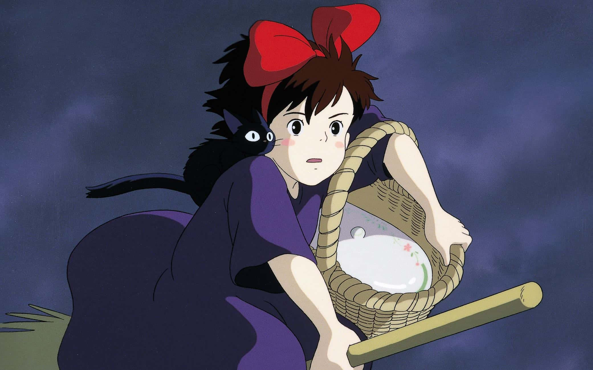 kiki's delivery service 桌布 壁紙 — 一位年輕女巫，戴著紅色蝴蝶結，帶著黑貓，在陰暗多雲的天空下騎著掃帚提著籃子。