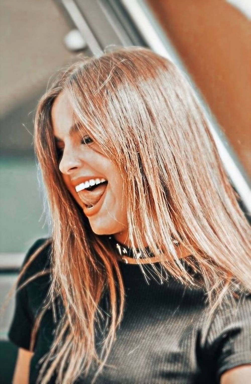 Celebrity 桌布 壁紙 — 一位年輕女性留著金色長髮，穿著黑色上衣和頸鍊，開懷大笑。