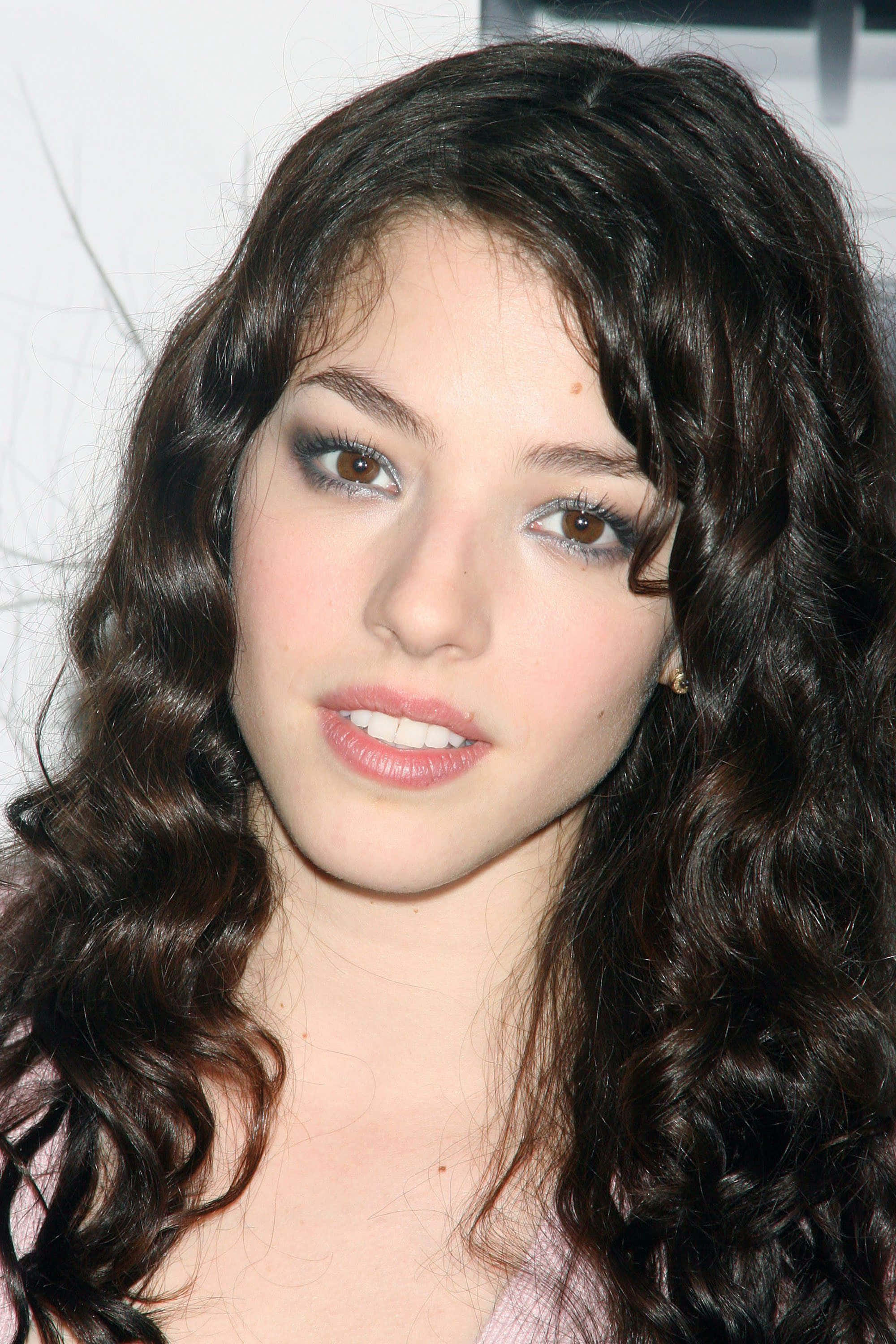 Olivia Thirlby 桌布 壁紙 — 一位年輕女性的特寫肖像，擁有深色波浪頭髮和柔和妝容，直視鏡頭。
