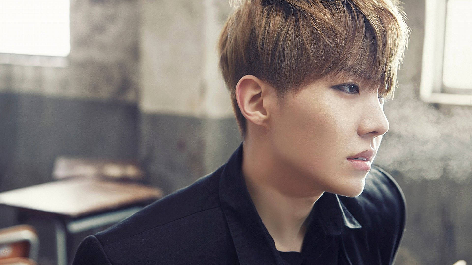 BTS J-hope Skool Luv Affair 壁紙 — 一位年輕男子，梳著棕色造型頭髮，深色眼睛，在昏暗的房間裡，煙霧在他臉龐附近繚繞，他若有所思地看向一旁。