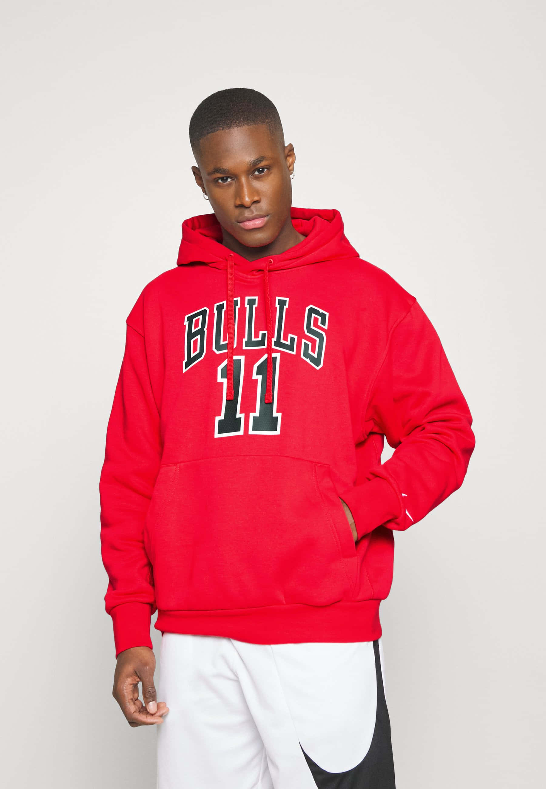 Red Hoodie 桌布 壁紙 — 一位年輕男子穿著大膽的紅色Bulls 11連帽衫，在純色背景前自信地站立。