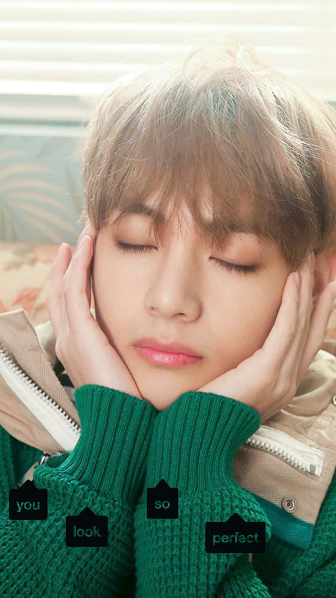Taehyung Cute 桌布 壁紙 — 一位年輕男子閉上眼睛，雙手托頭，身穿綠色毛衣在室內休息。