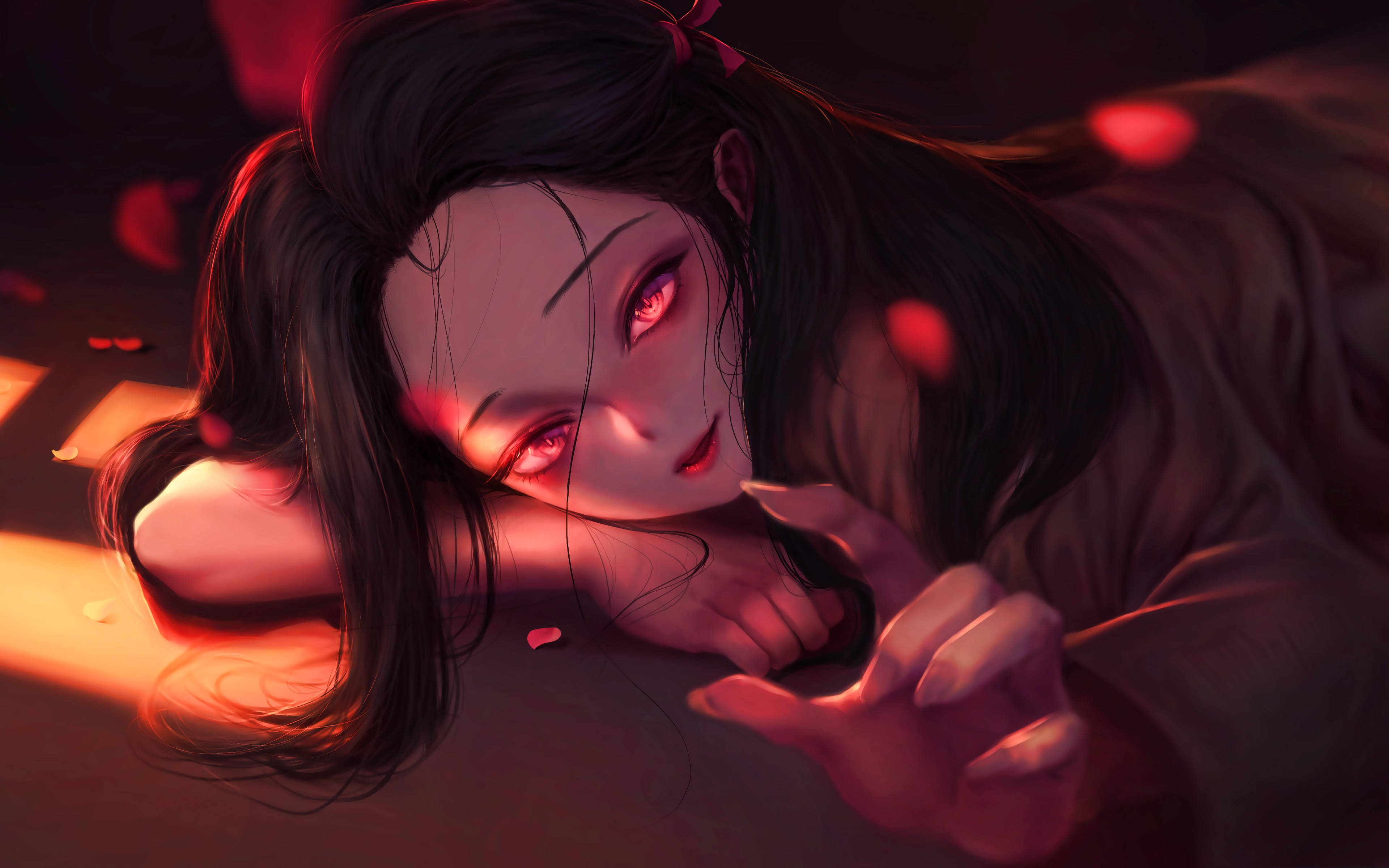 Demon Slayer 4K Nezuko Red 壁紙 — 一位年輕的動漫女孩，擁有發光的紅色眼睛和深色頭髮，趴在地上，伸出一隻手，紅色花瓣在溫暖的光線中飄浮在她周圍。