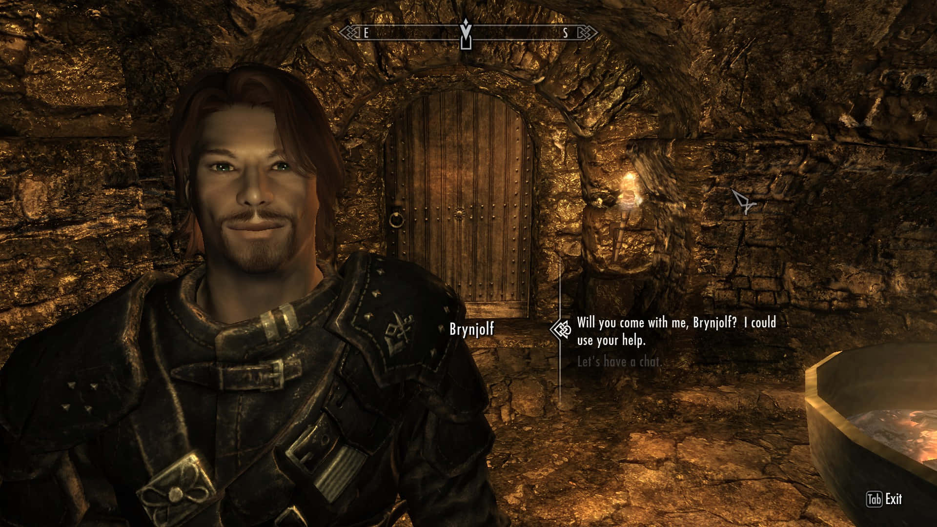 Skyrim Brynjolf 桌布 壁紙 — 一位強壯的諾德戰士身穿皮甲，在昏暗的石造地牢中微笑，地牢有木門和搖曳的火炬光。