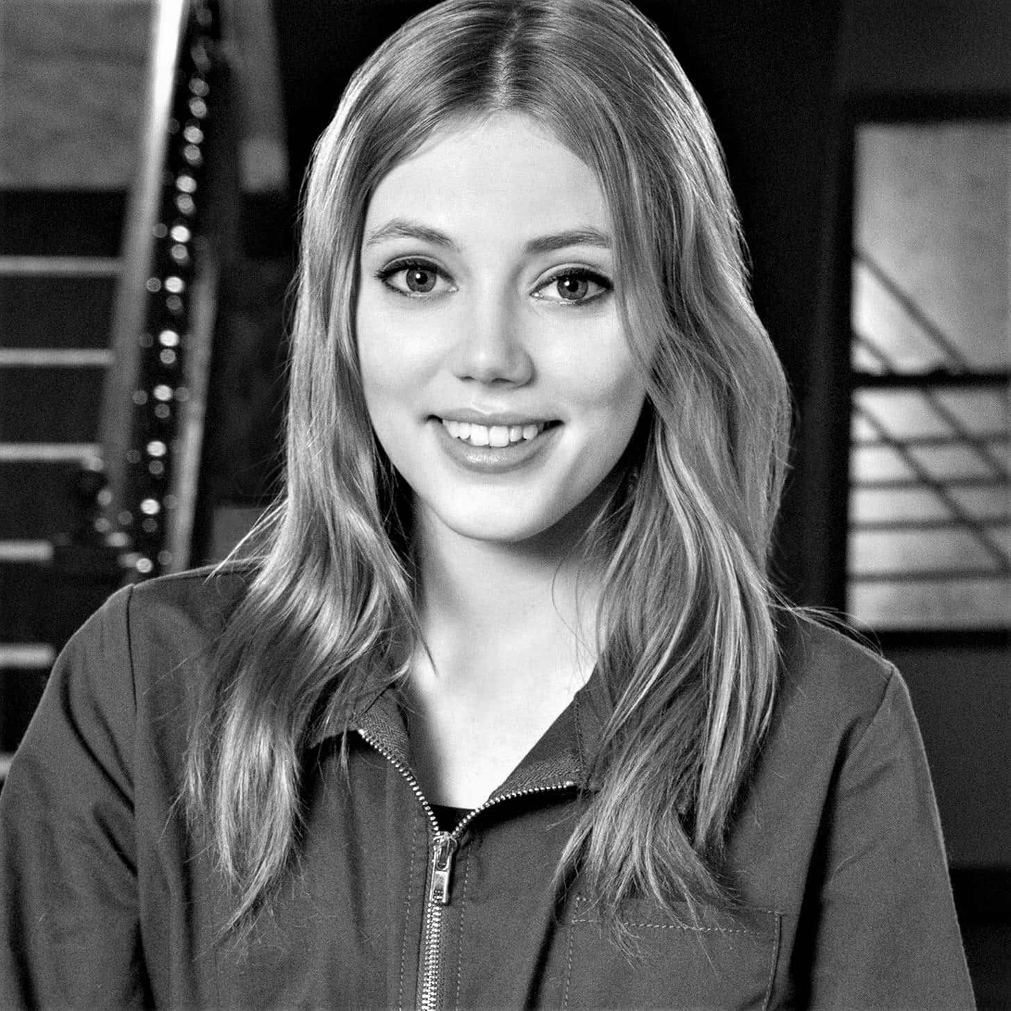 Grace Van Dien 桌布 壁紙 — 一位微笑的年輕女性的黑白肖像，長髮，穿著拉鍊外套。