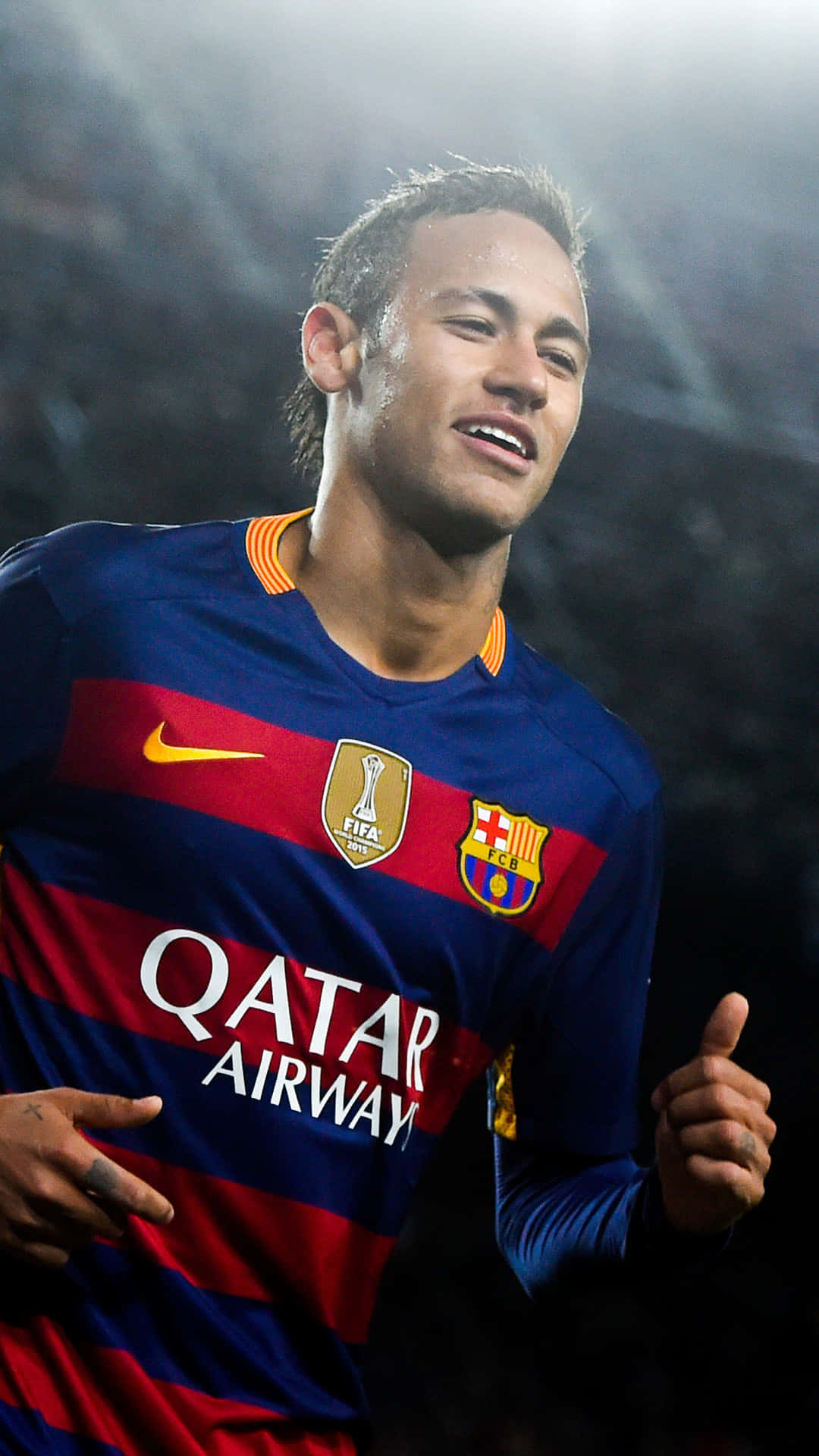 Neymar 桌布 壁紙 — 一位微笑的足球員身穿藍紅間條球衣，在球場燈光下豎起大拇指。