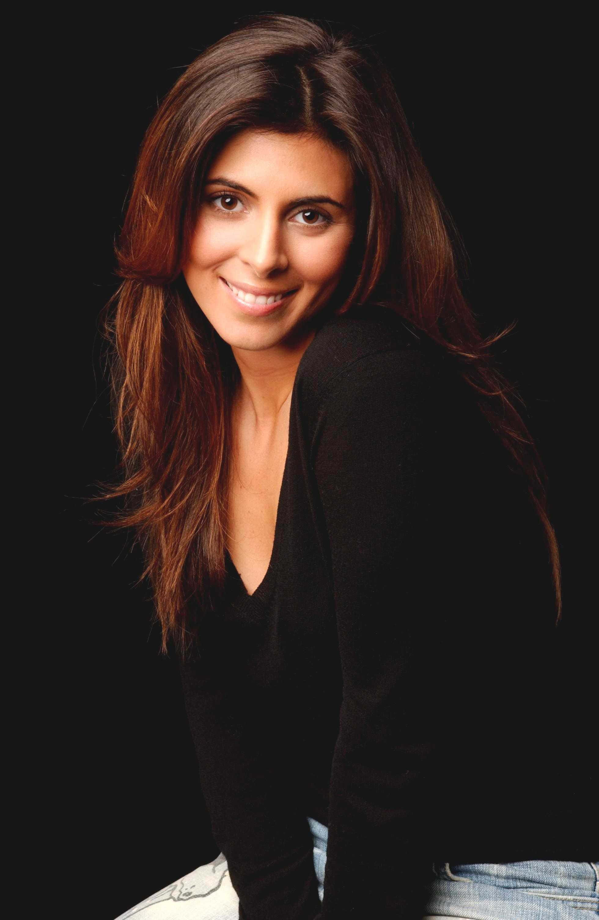 Jamie Lynn Sigler 桌布 壁紙 — 一位微笑的長髮棕髮女性，身穿黑色上衣，背景為深色。