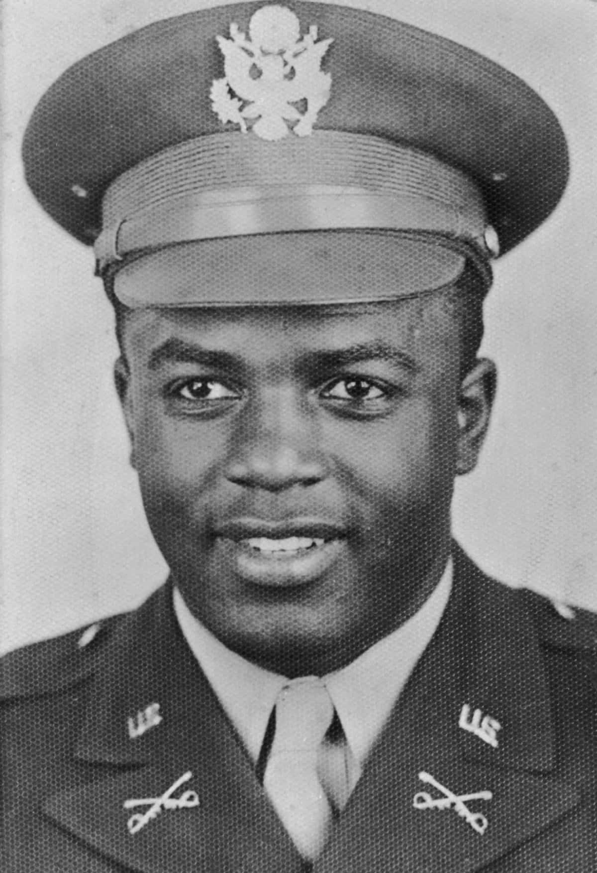 Jackie Robinson 桌布 壁紙 — 一位微笑的非裔美國士兵身穿帶有徽章和帽子的美軍制服的黑白肖像。