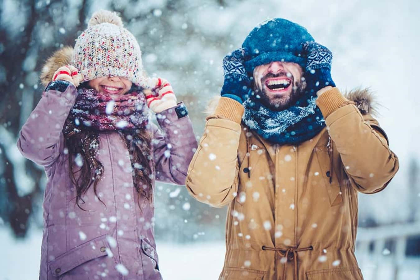 寒冷 桌布 壁紙 — 一位快樂的父親和女兒在冬日仙境中，雪花飄落，開懷大笑。