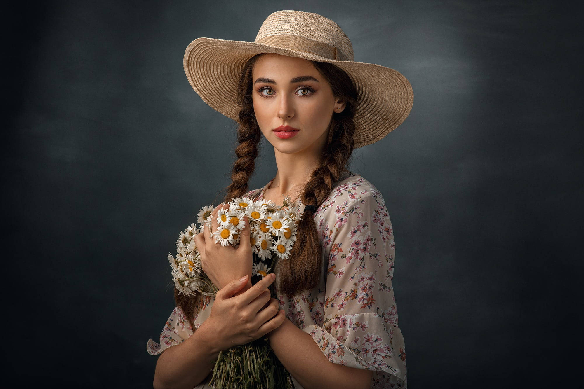 Beautiful Woman 桌布 壁紙 — 一位戴草帽、穿碎花裙的年輕女子，在陰暗憂鬱的背景前捧著一束雛菊。