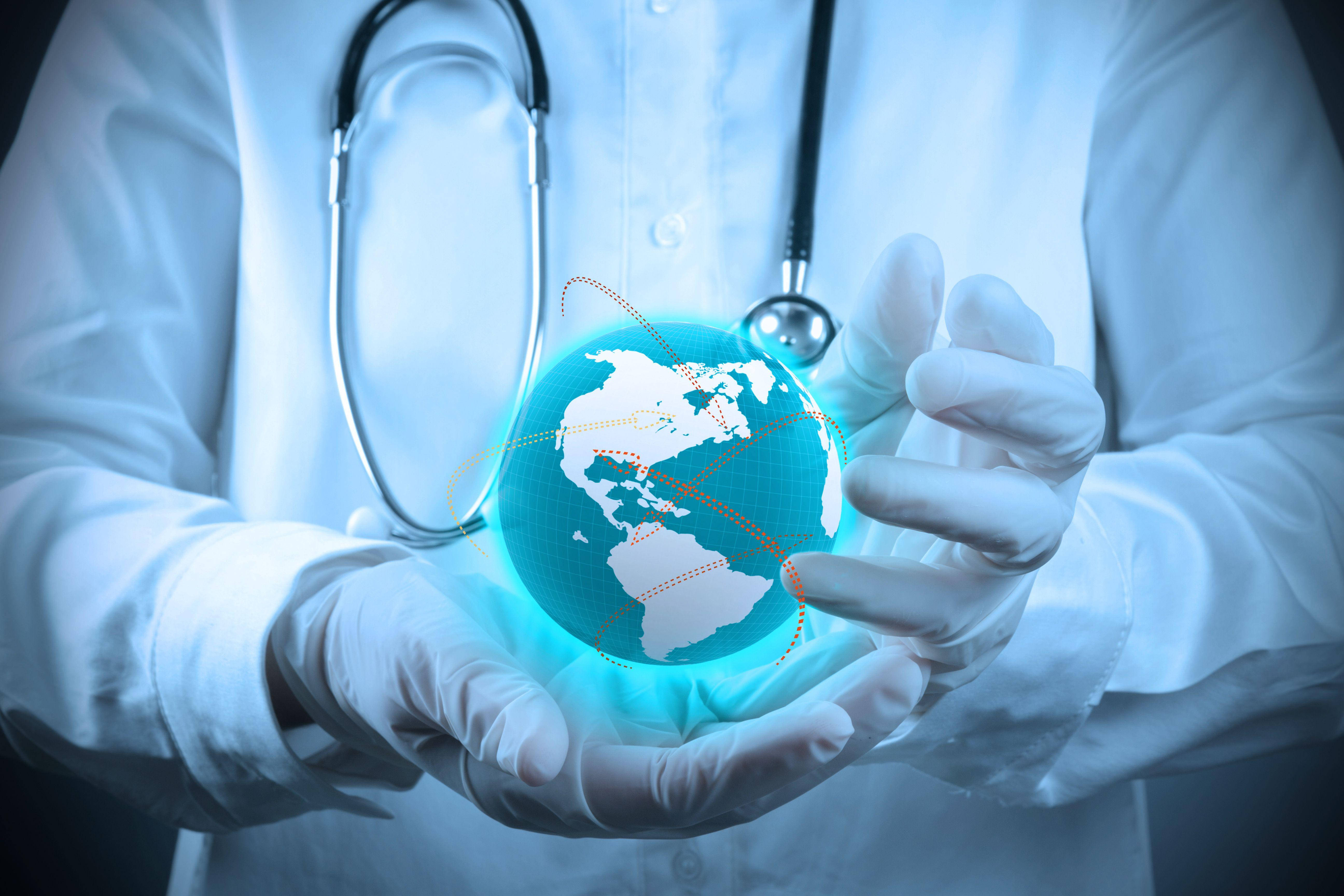 Stethoscope 桌布 壁紙 — 一位戴著白色手套的醫生，肩上掛著聽診器，手持發光的藍色數位地球儀。