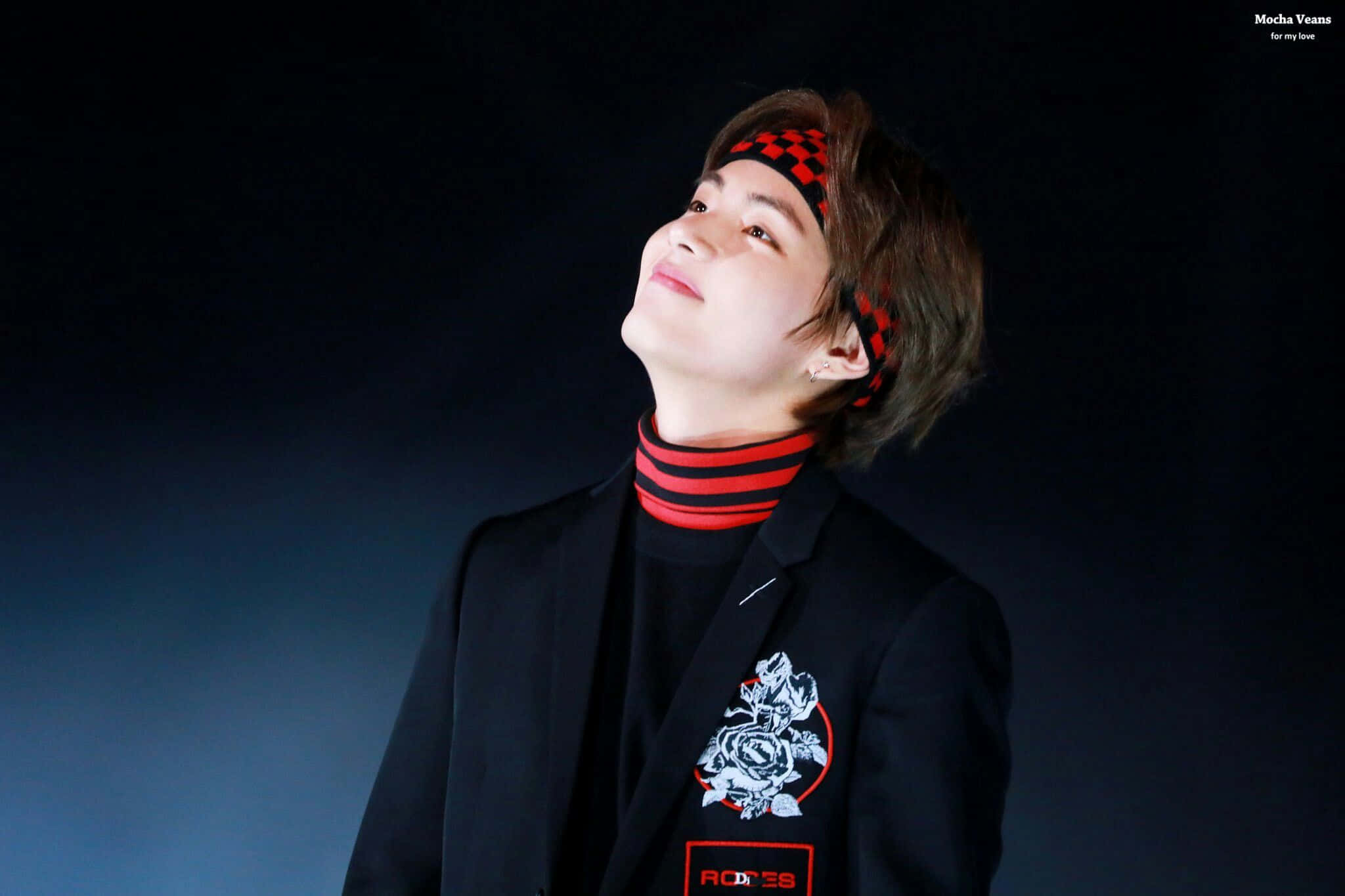 Taehyung Cute 桌布 壁紙 — 一位戴著紅色格仔頭帶的年輕男子，在柔和藍光照亮的黑暗工作室中向上凝視。