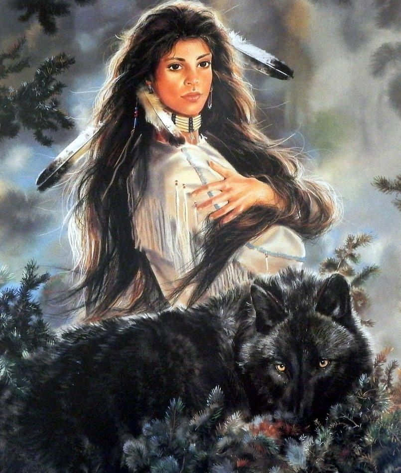 Black Magic Woman 桌布 壁紙 — 一位戴著羽毛頭飾的美洲原住民女性，在霧氣瀰漫的松樹林中，平靜地凝視著身旁的一隻黑狼。