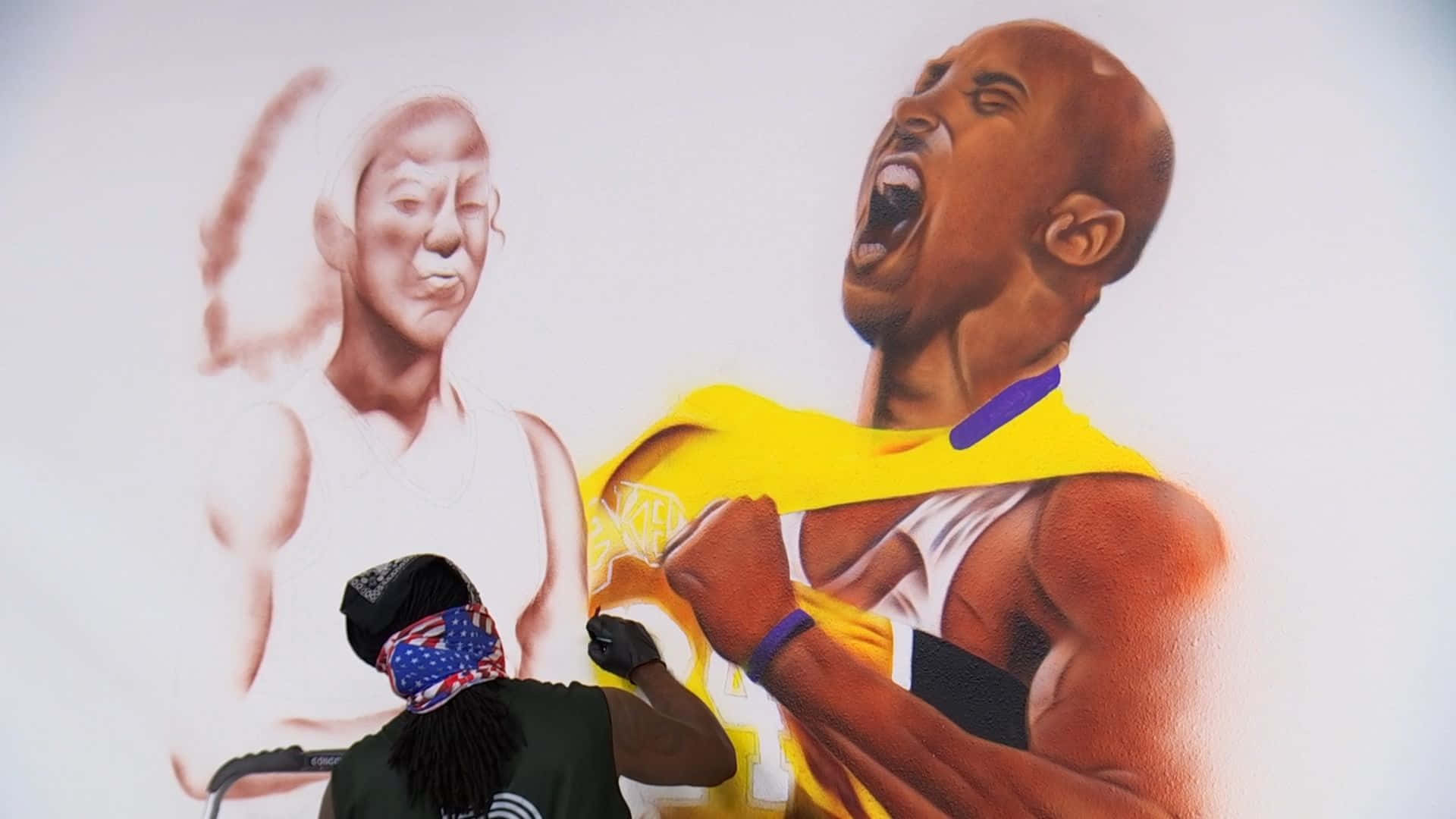 Kobe And Gigi 桌布 壁紙 — 一位戴著頭巾的藝術家正在繪畫一幅充滿活力的壁畫，描繪身穿湖人球衣的高比拜仁勝利咆哮，旁邊是褪色的當勞侵肖像。