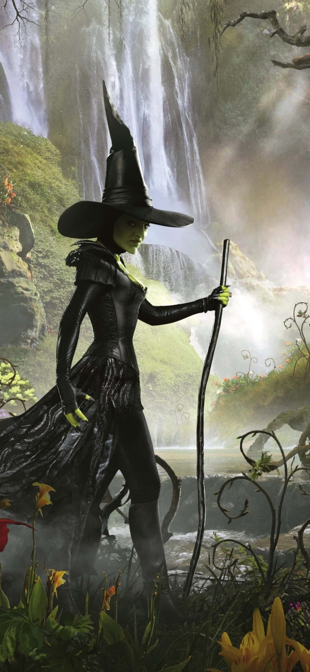 Dark Wizard 桌布 壁紙 — 一位戴著高帽的黑暗女巫站在霧氣瀰漫的瀑布前，手持被發光植物環繞的法杖。