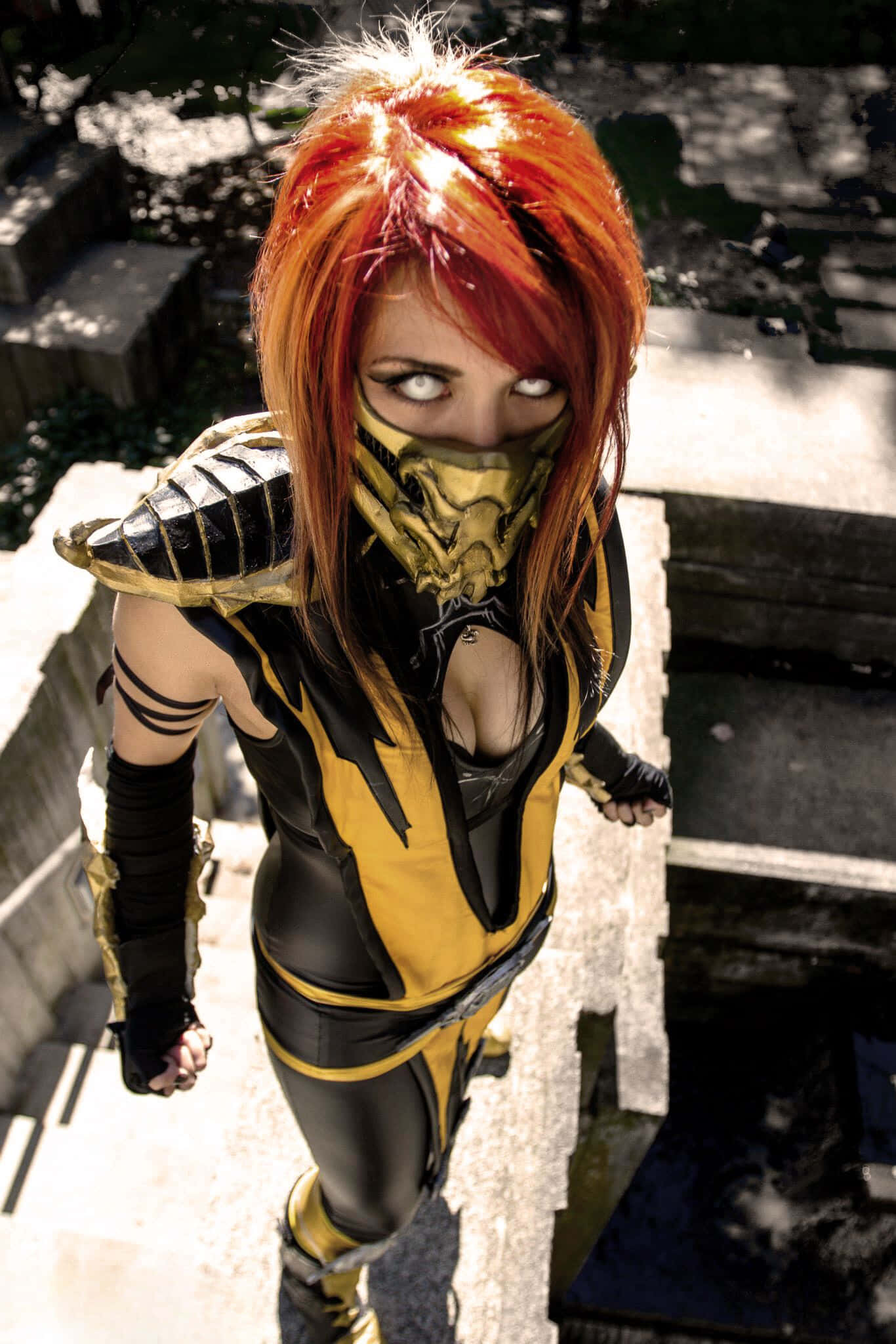 Mortal Kombat Cosplays 桌布 壁紙 — 一位扮演《真人快打》中蠍子（Scorpion）精細服裝的角色扮演者，站在石階上，眼神凌厲，火紅頭髮。