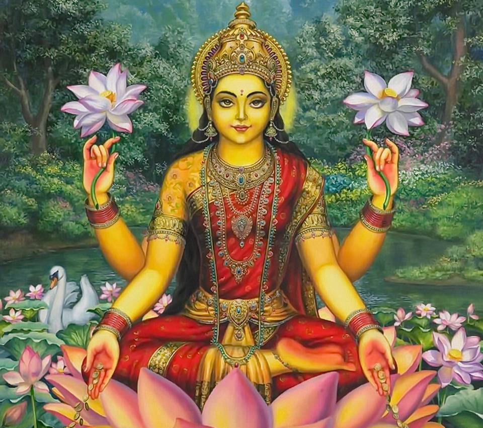 Lakshmi 桌布 壁紙 — 一位擁有四臂的神聖女神安詳地坐在蓮花上，手持粉紅色花朵，周圍有天鵝和茂密的綠植。